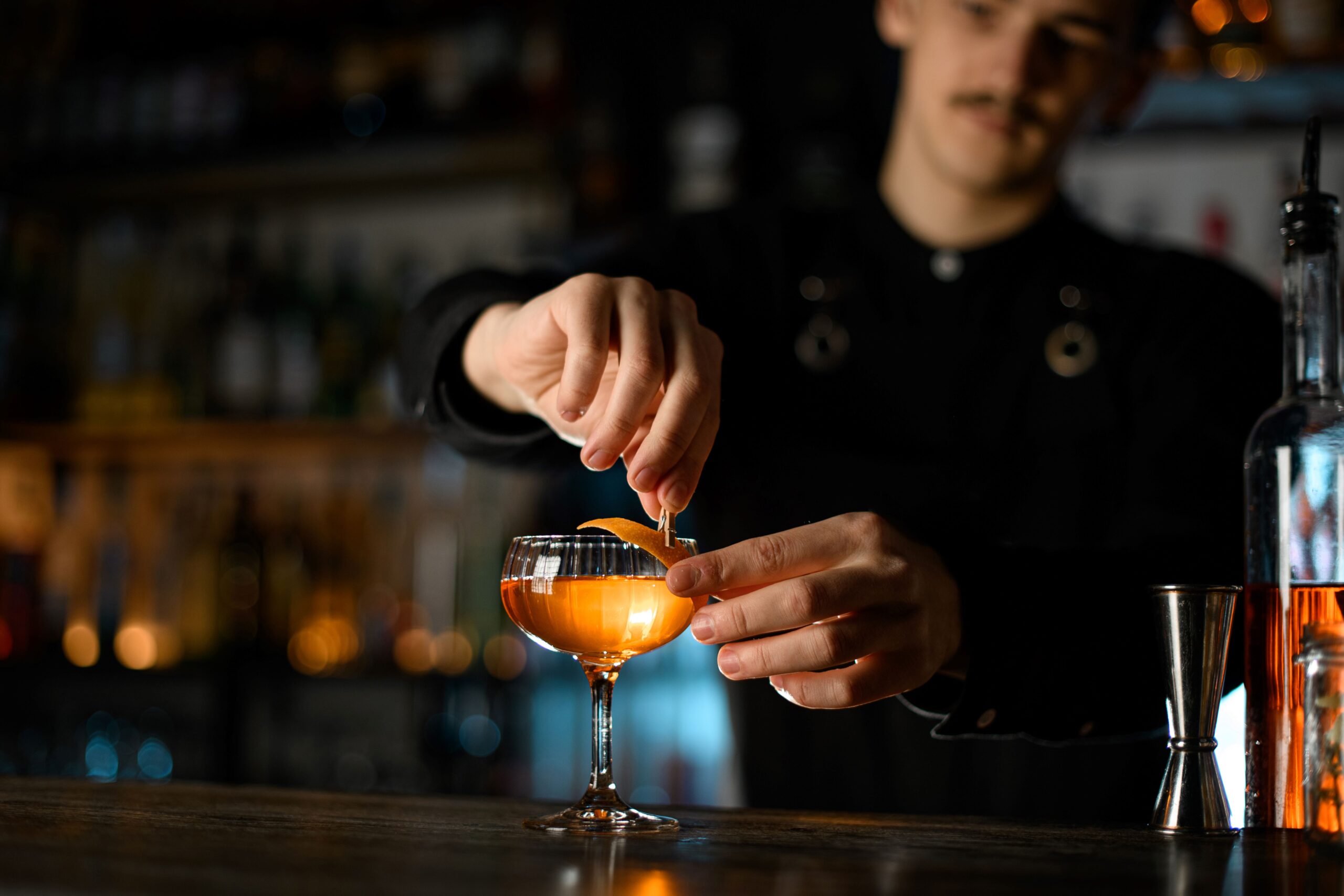 Eine Person macht ein Cocktail an einem Bar Tisch 